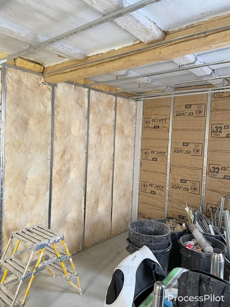 Artisan RGE réalisant une isolation thermique par l'extérieur avec des matériaux Isover sur un chantier de rénovation.